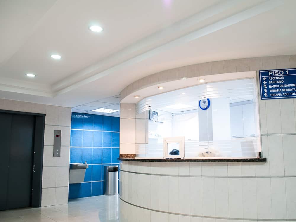 Mostrador de recepción de una clínica con la sala de espera al fondo